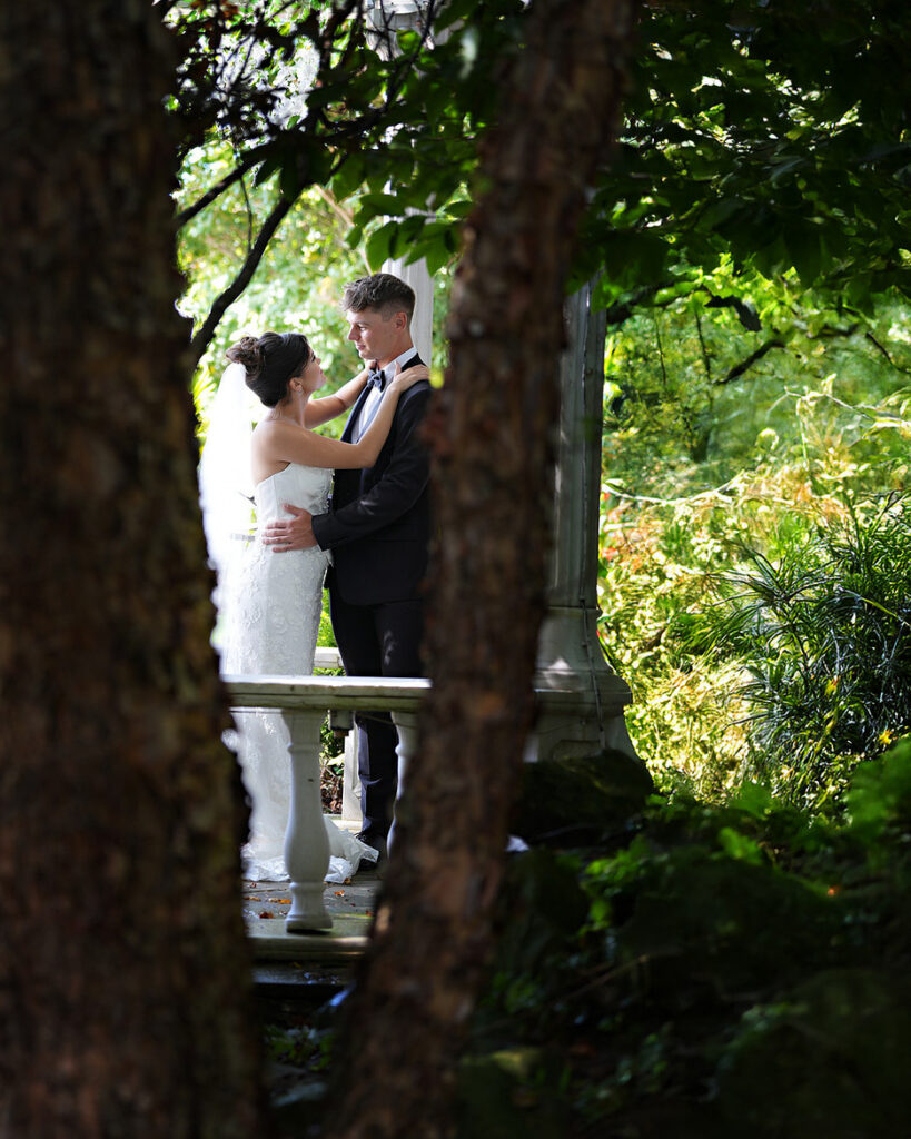 Candid bride and groom sharing an authentic hidden moment on wedding day, intimate portrait.
