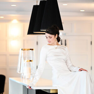 Bride sitting alone on the bar at Waters Edge in Centerport during wedding day portraits