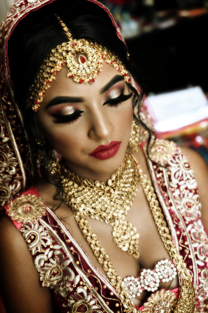 Close-up of Desi bridal details in muted tones showing jewelry, fabric texture, and bridal accessories.