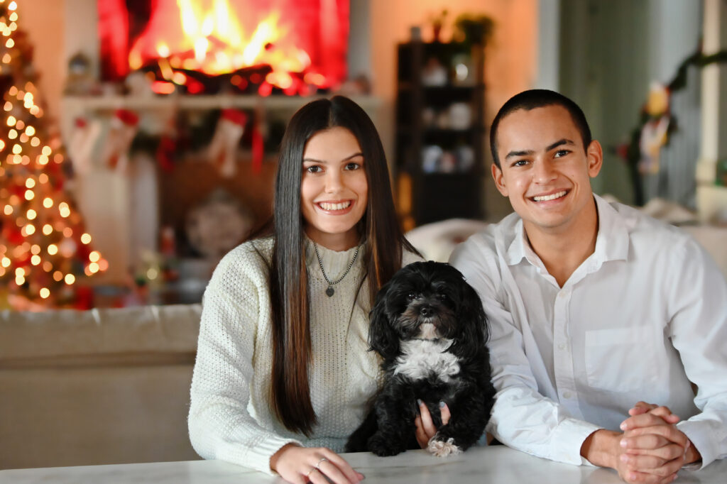 Adult siblings with their dog during a holiday studio portrait session in Windermere, captured in soft seasonal lighting.