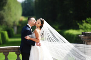 Groom kissing the bride during wedding portraits at Old Westbury Gardens on Long Island