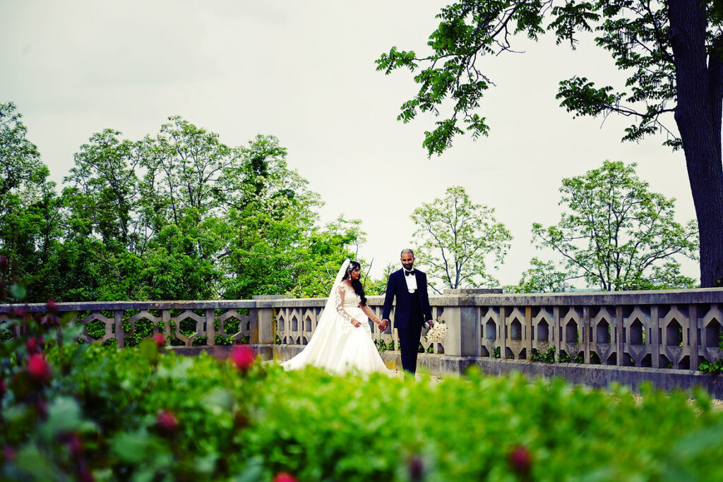 Bride and groom walking together at Old Westbury Gardens during their Long Island wedding portraits