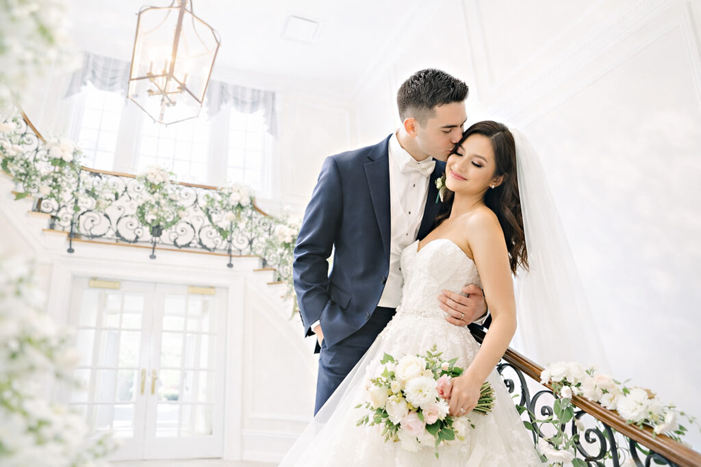 Elegant bride and groom posing romantically on staircase at Muttontown Club wedding in Long Island by Doug Gordon Patken Photographer