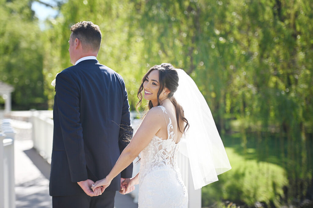 storytelling wedding photography of bride looking back while walking with groom outdoors