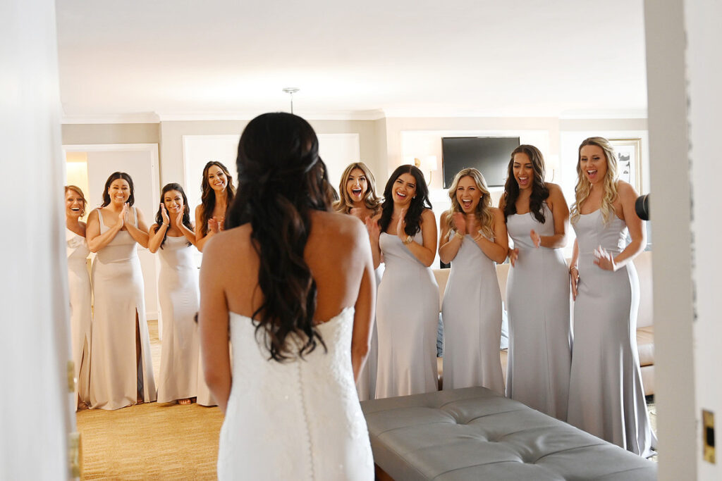 storytelling wedding photography of bridesmaids reacting to bride reveal indoors