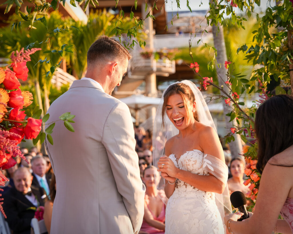 Bride smiling during beach ceremony under floral arch at Crescent Beach Club Long Island New York
