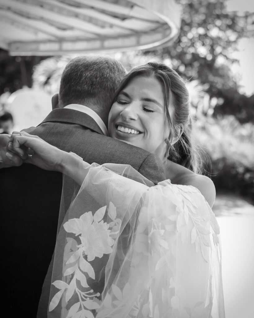 Black and white bride and dad hug moment at Crescent Beach Club Long Island New York wedding photographed by Doug Gordon of Patken Photographer