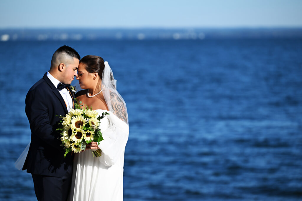 Bride and groom close portrait with bouquet by the ocean at Crescent Beach Club Long Island New York