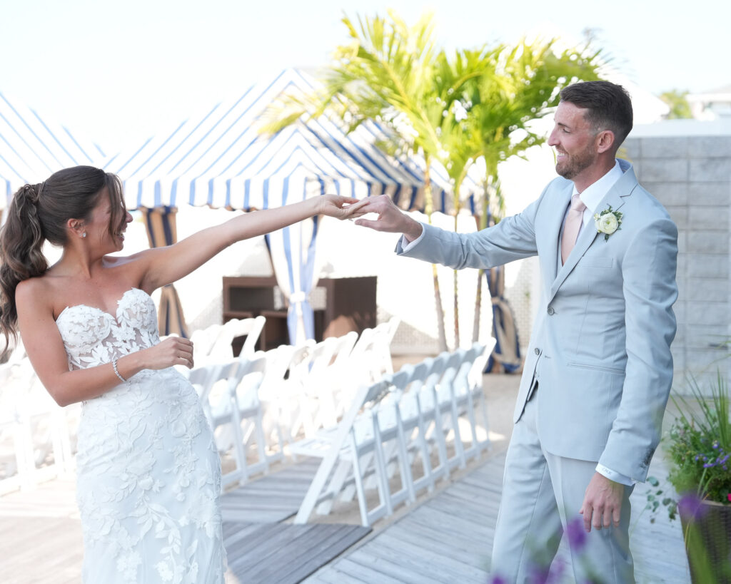 Bride and groom reaching hands and smiling during ceremony aisle moment at Crescent Beach Club Long Island New York