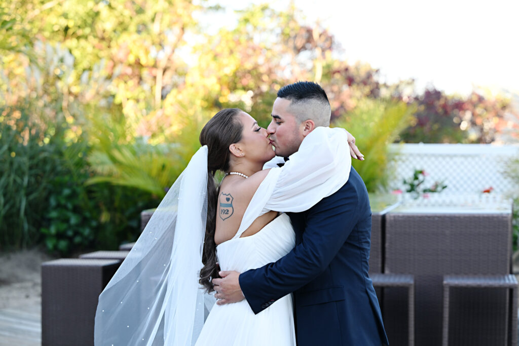 Bride and groom kissing outdoors at Crescent Beach Club wedding in Long Island New York
