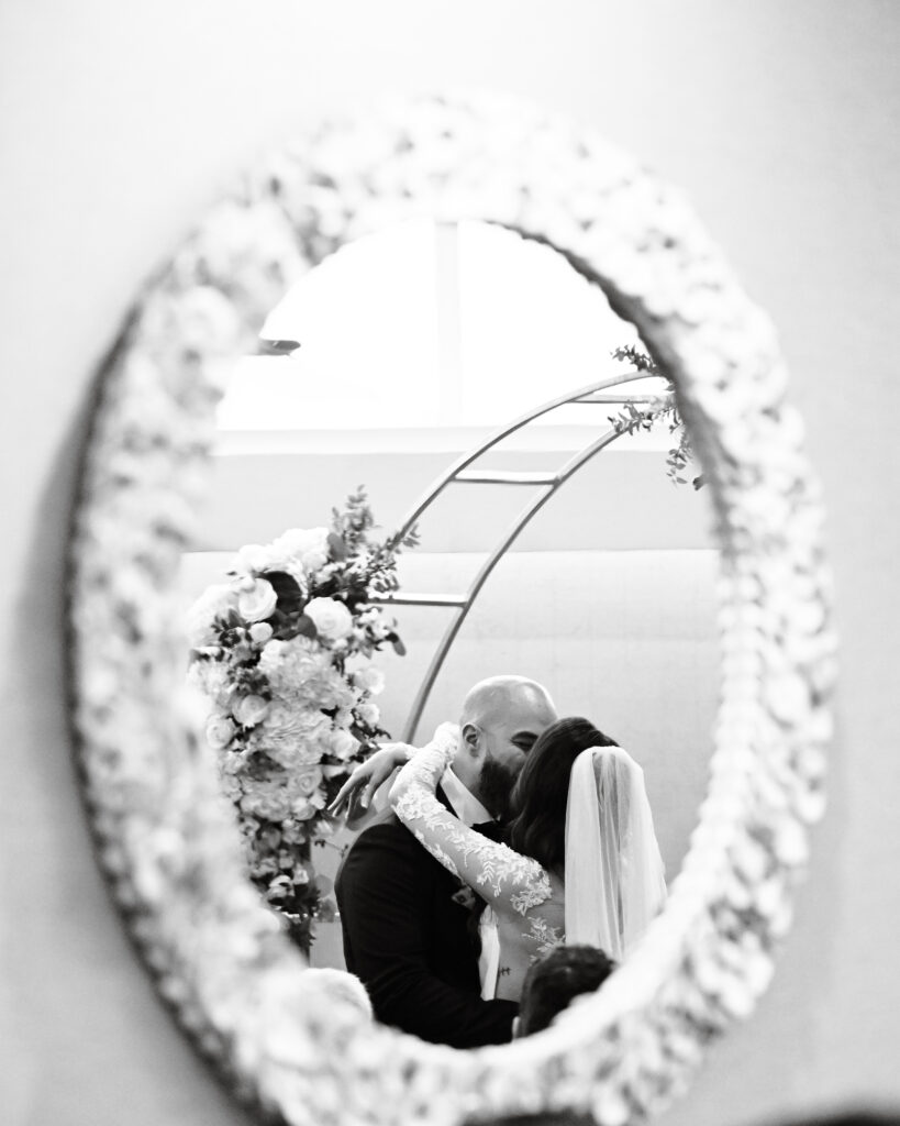 Black and white mirror reflection of bride and groom kissing at Crescent Beach Club Long Island New York
