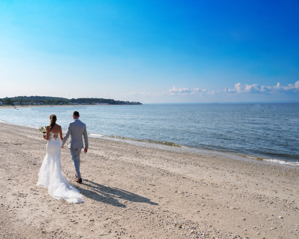 Bride and groom walking along the beach at Crescent Beach Club Long Island New York wedding