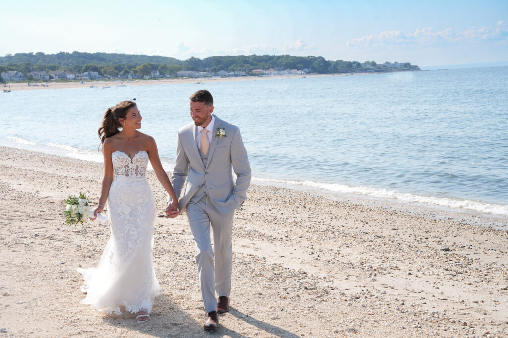 Bride and groom walking hand in hand on the beach at Crescent Beach Club Long Island New York