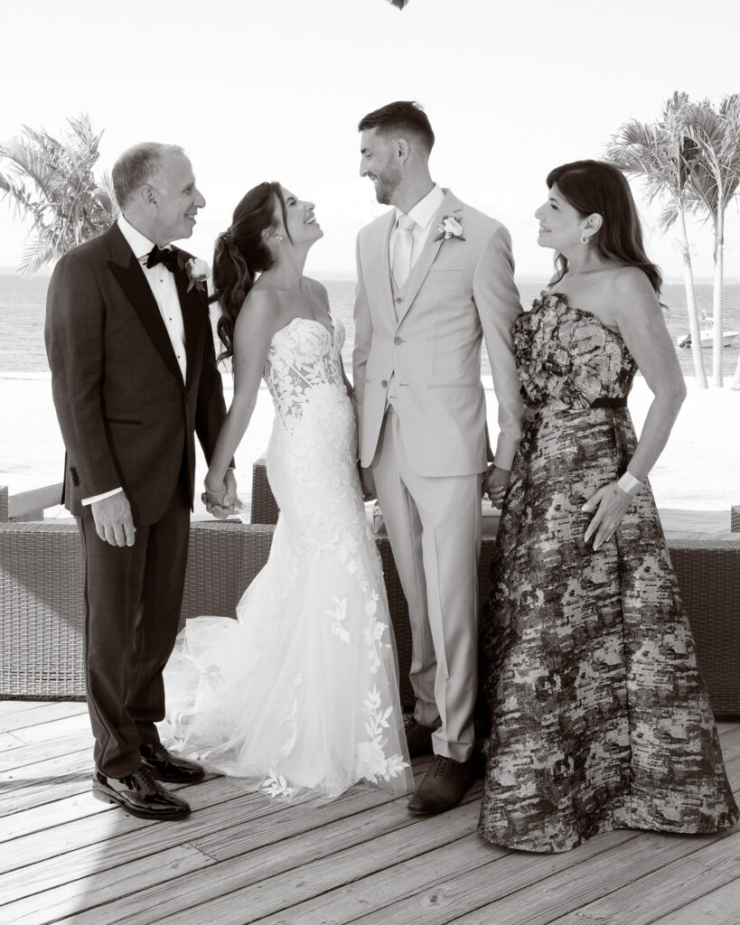 Black and white natural family portrait with bride groom and parents at Crescent Beach Club wedding Long Island New York