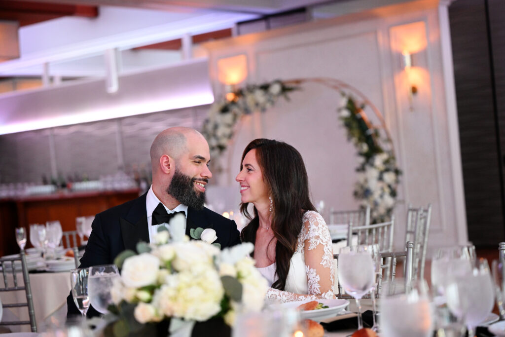 Bride and groom smiling at sweetheart table during reception at Crescent Beach Club Long Island New York