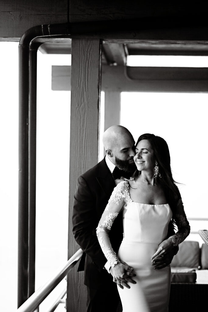 Black and white portrait of bride and groom embracing in doorway at Crescent Beach Club Long Island New York