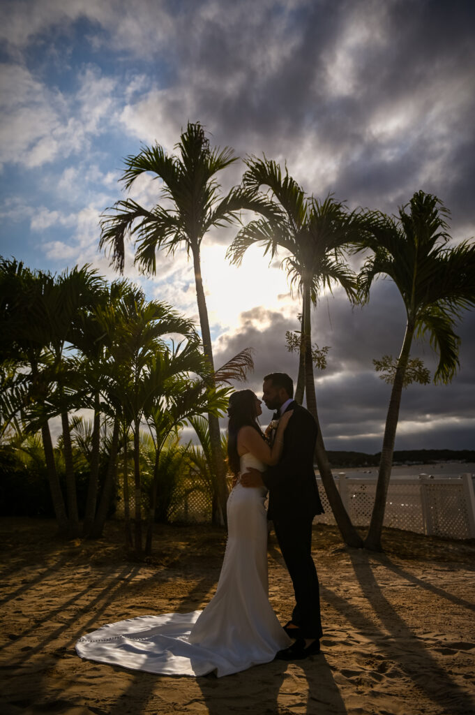 Bride and groom silhouette at sunset near palm trees at Crescent Beach Club, Long Island, New York.