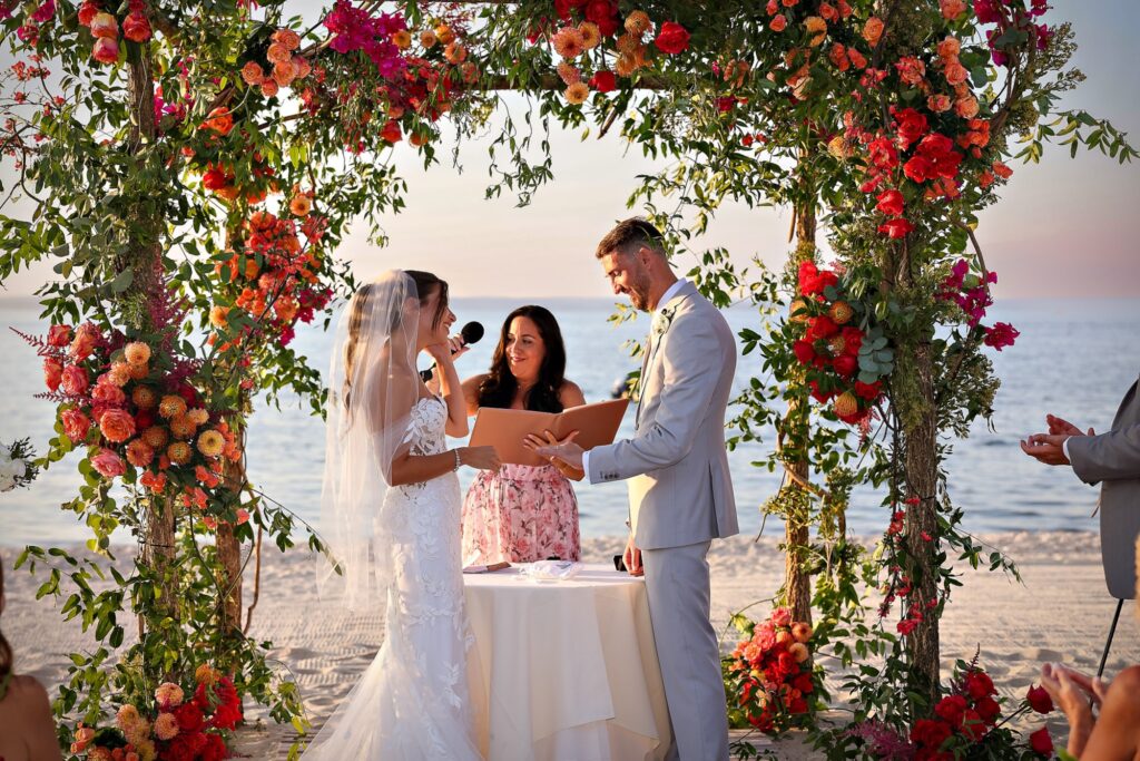 Crescent Beach Club wedding photo at Bayville, Long Island, New York: crescent beach club wedding ceremony ring exchange under arch. Photo by Doug Gordon | Patken Photographer.