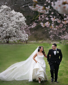 Bride and groom strolling through cherry blossoms at Planting Fields Arboretum in Oyster Bay, NY