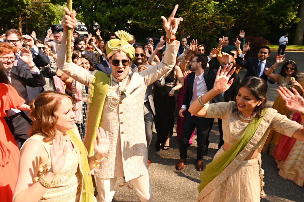 Groom dancing with guests during Indian wedding reception at Flowerfield