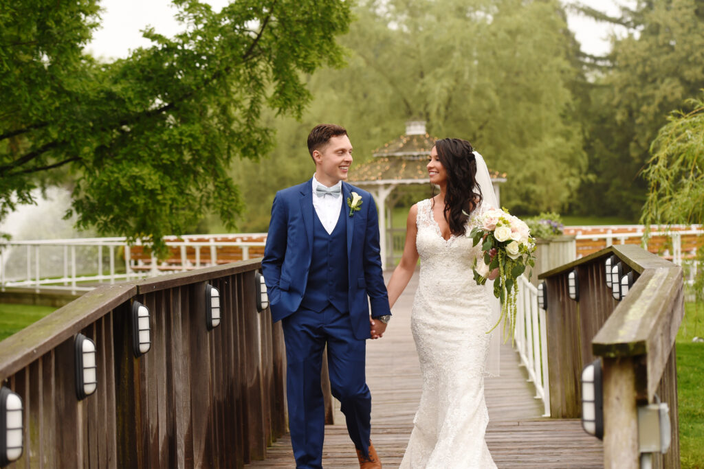 Bride and groom walking across bridge at Flowerfield Long Island