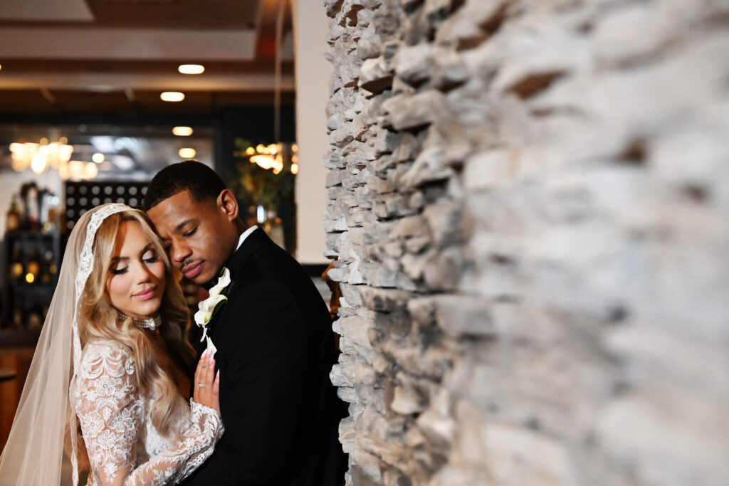 Elegant portrait of bride and groom near stone wall at Flowerfield