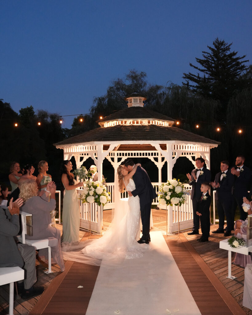 Night ceremony entrance under lit gazebo at Flowerfield wedding