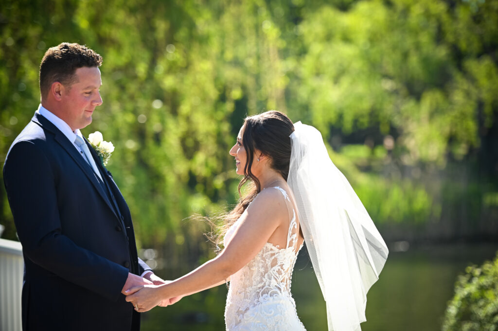 Bride reaching for groom during Flowerfield ceremony moment