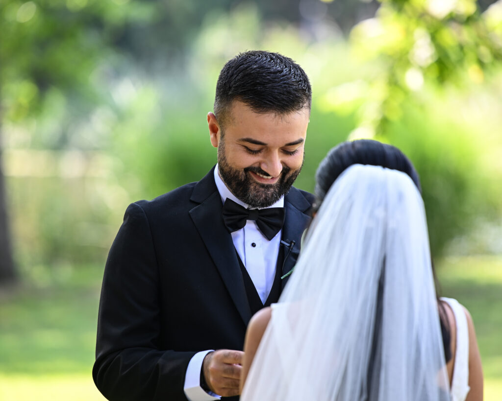 Groom smiling at bride during Flowerfield wedding ceremony
