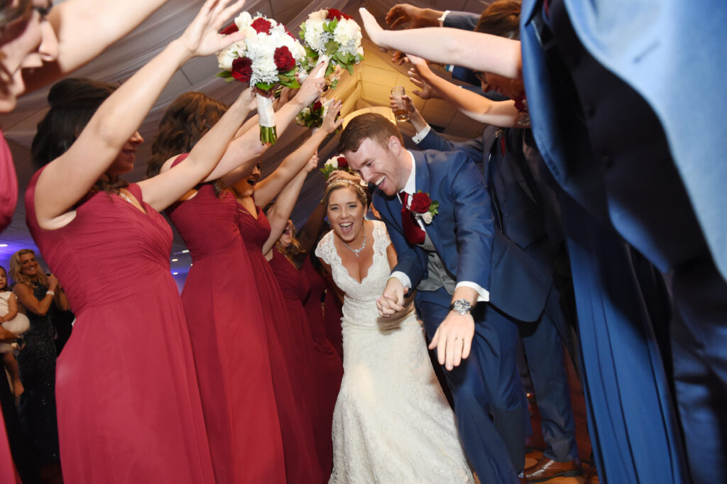 Wedding celebration with bridal party lifting couple at reception