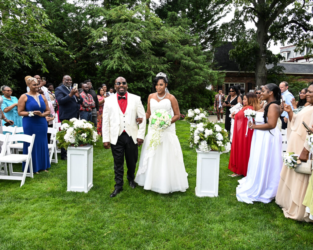 Westbury Manor Bride and groom walking down aisle during outdoor ceremony on manicured Long Island lawn