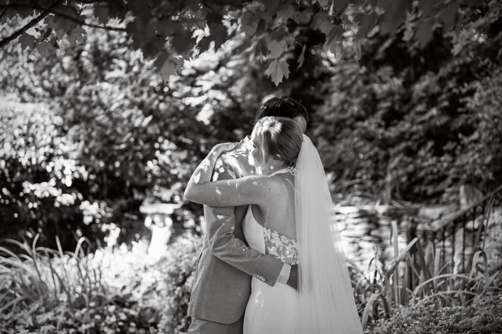 Black and white portrait of bride and groom embracing outdoors at Long Island wedding venue