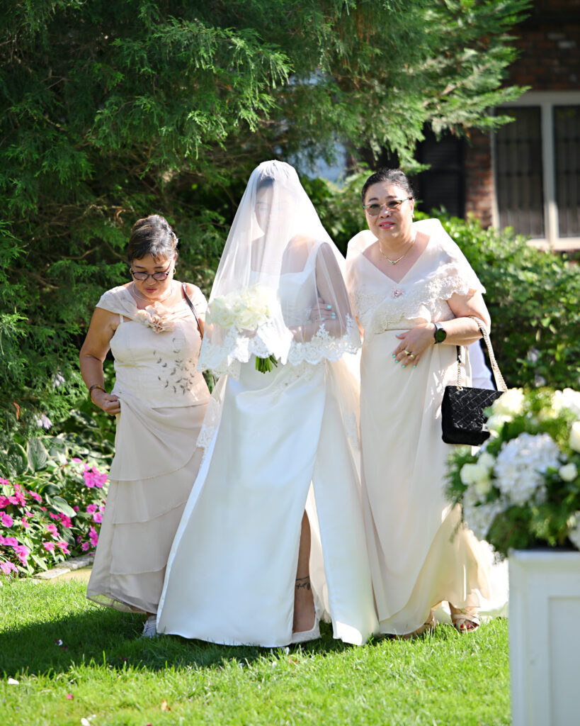Moms and bride entering outdoor ceremony together at Long Island wedding