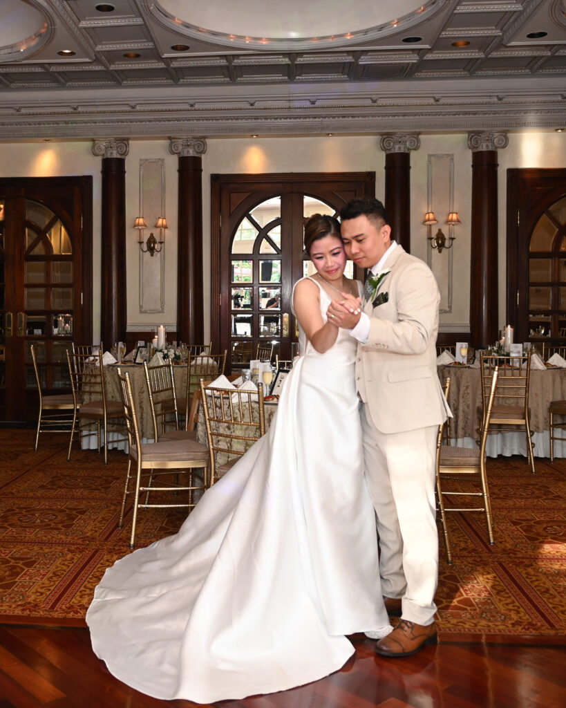 Bride and groom first dance near large windows at Long Island wedding venue at Wetsbury Manor