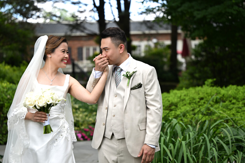 Bride and groom walking through gardens at Westbury Manor wedding in Long Island NY