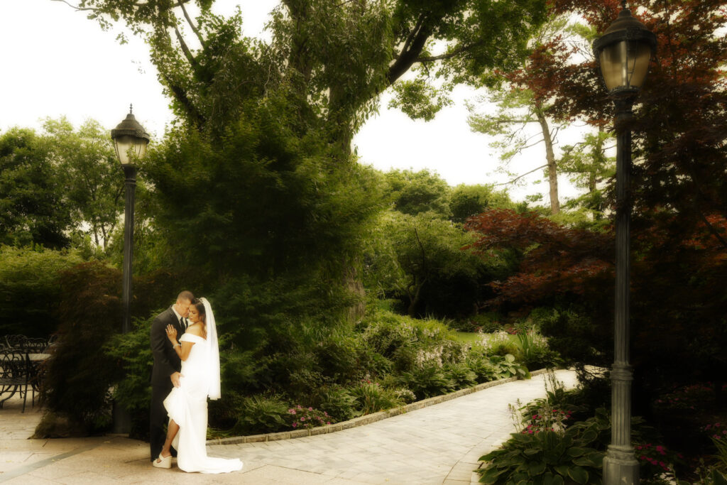 Bride and groom standing on stone bridge at Westbury Manor wedding venue