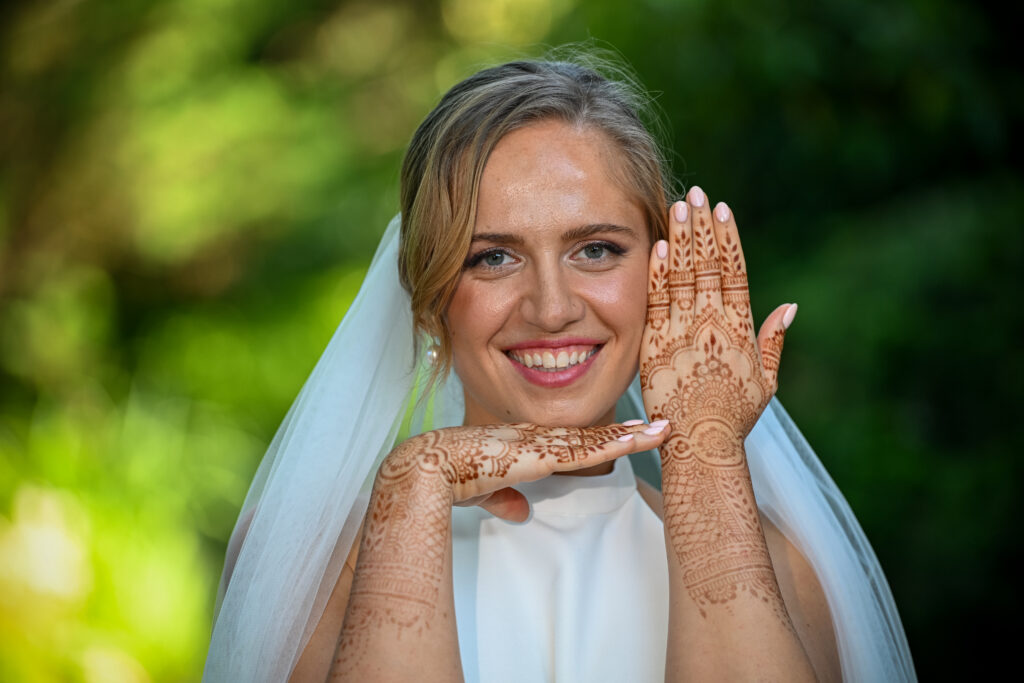 Bride smiling showing henna hands at Westbury Manor wedding Long Island