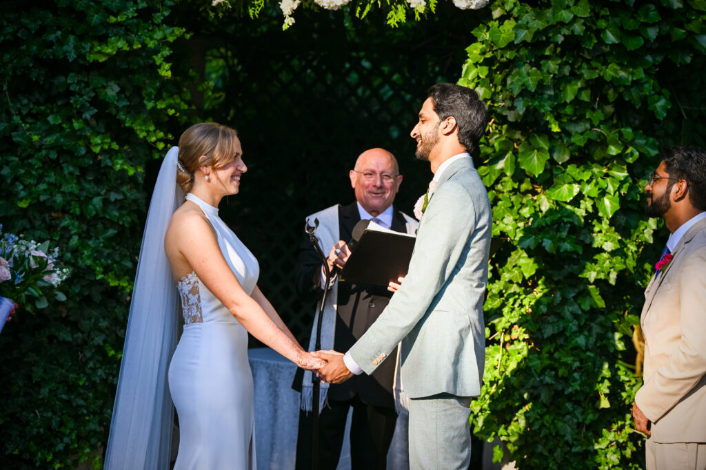 Bride and groom holding hands during outdoor ceremony at Westbury Manor