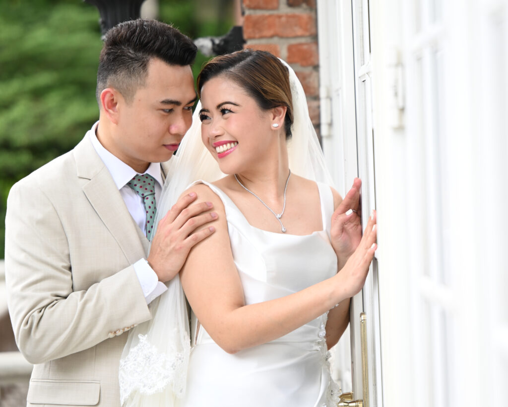 Bride and groom portrait against brick wall at Westbury Manor Long Island
