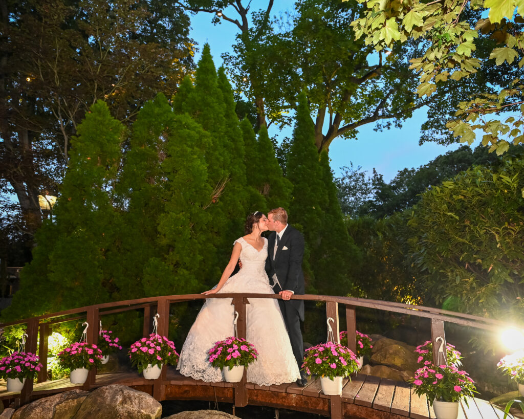 Bride and groom on bridge in Westbury Manor gardens Long Island