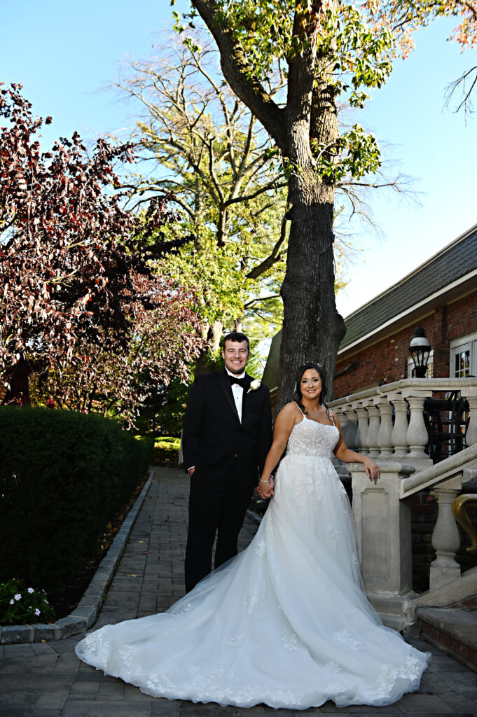 Bride standing under trees in Westbury Manor gardens Long Island