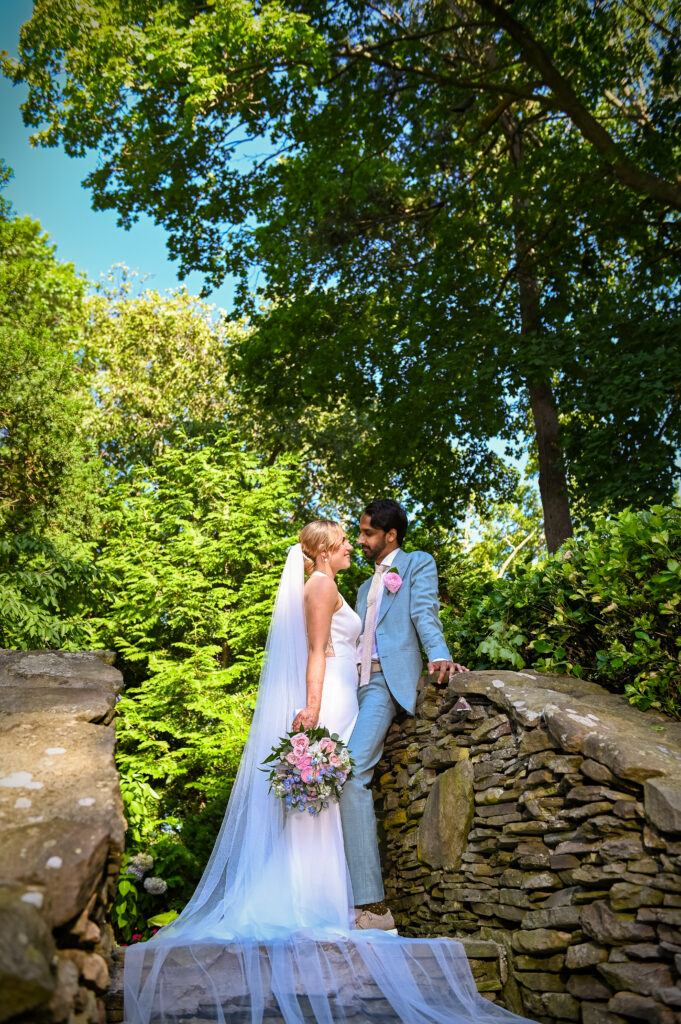 Bride and groom standing on stone bridge at Westbury Manor Long Island wedding venue