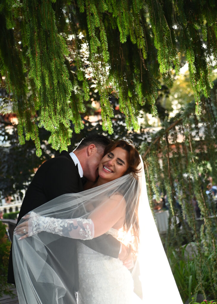 Bride and groom under veil in Westbury Manor gardens Long Island