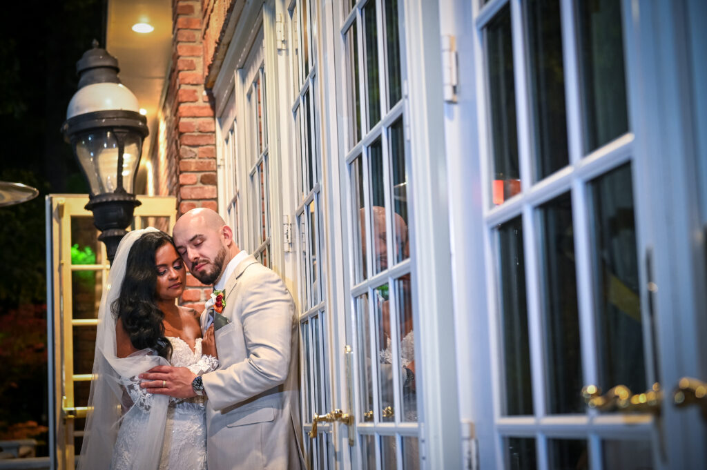 Bride and groom portrait beside windows at Westbury Manor Long Island