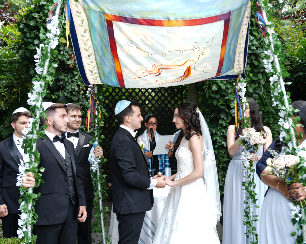 Bride and groom under chuppah during Westbury Manor garden ceremony