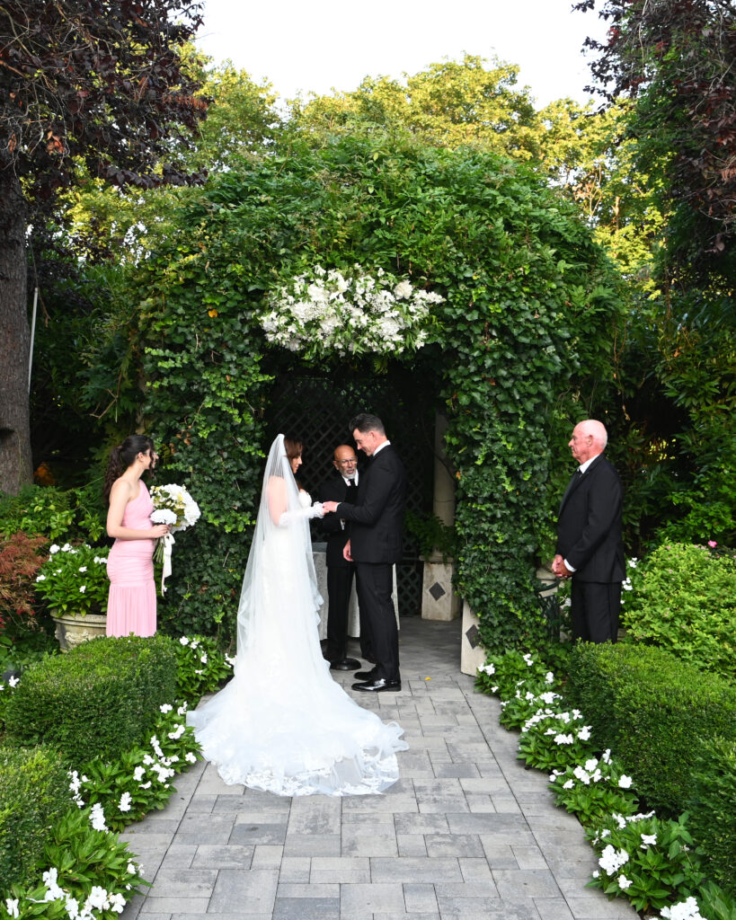 Bride walking down garden aisle at Westbury Manor Long Island wedding