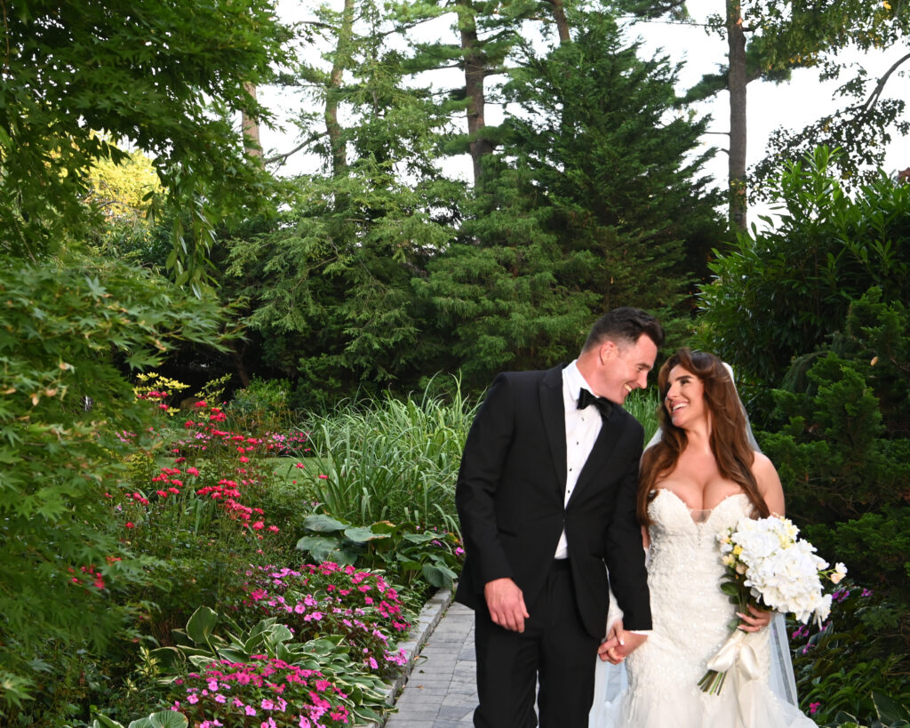 Bride and groom portrait near waterfall feature at Westbury Manor Long Island