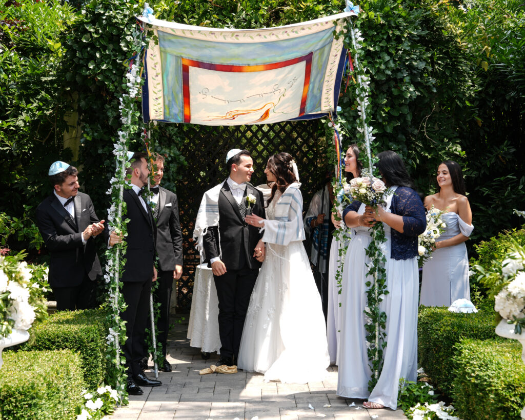 Bride and groom celebrating under chuppah at Westbury Manor Long Island