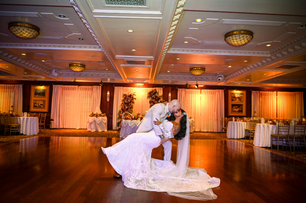 Bride and groom dipping during first dance in Westbury Manor ballroom