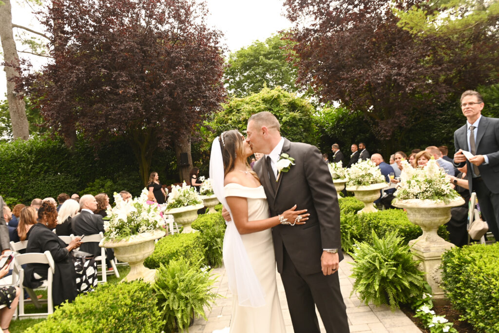 Bride and groom kissing on garden terrace at Westbury Manor Long Island wedding venue